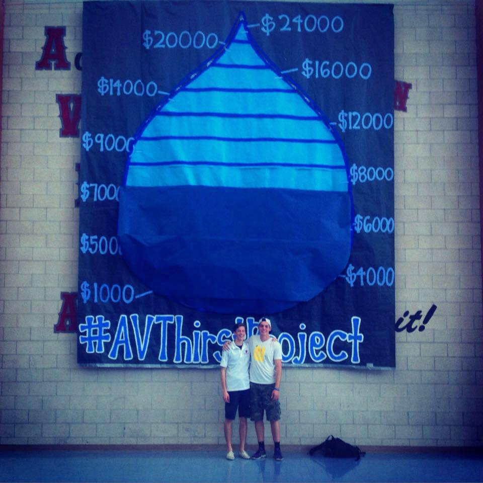 Evan Wesley and Harrison Kelly of Arbor View High School, in front of a banner in his school showing the goal and fundraising progress of the students at Arbor View High School to build 2 freshwater wells in Swaziland.