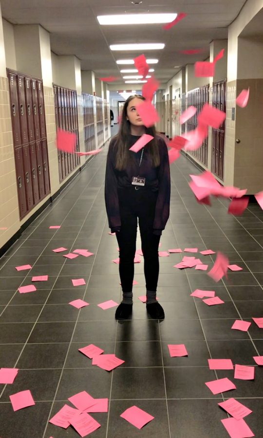 SHS sophomore Cassie Oppelt standing among a pile of excused absence notes. 