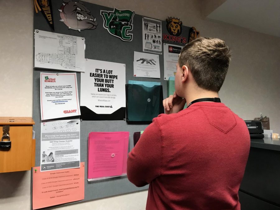 A SHS student analyzing their college options by looking at college flyers on a bulletin board. 