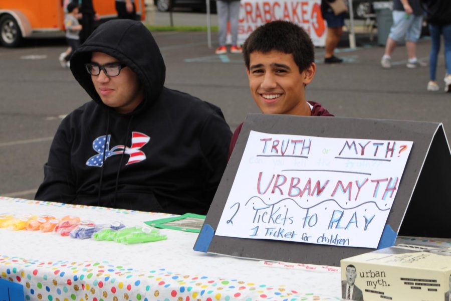Two students run a truth or myth carnival game.
