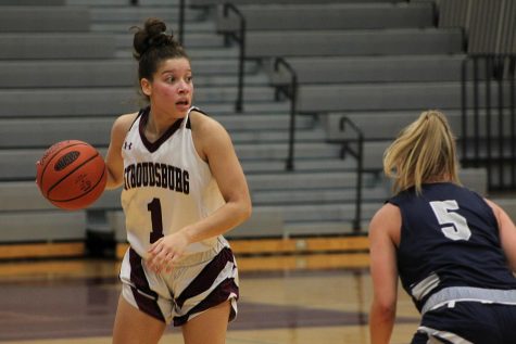 Girls Varsity Basketball player Samantha Columna about to pass the ball to a teammate. 