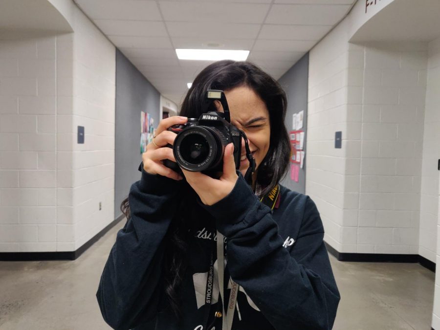 Yearbook photographer junior Julia Gallo is seen above, posing for what she does best: photos.