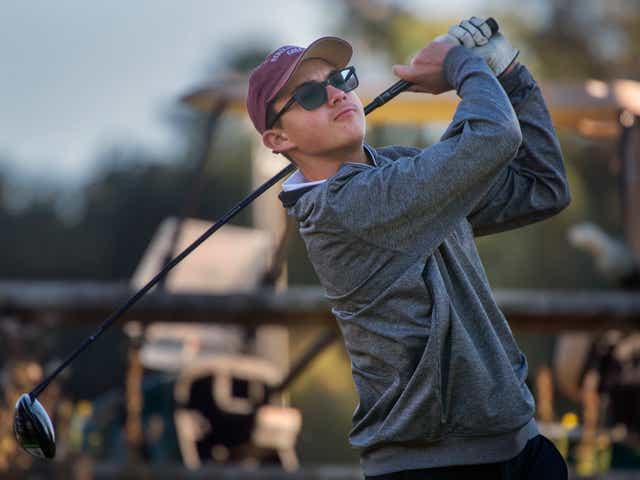 Hunter Probst swinging a golf club. He shot 69 this season.