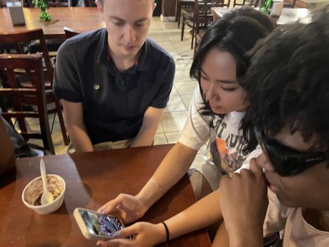 Three teens are having fun sharing TikToks on their phones.