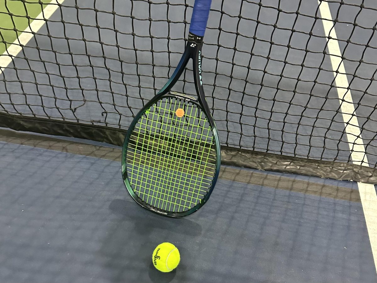 Image of a tennis racket and tennis ball posed on a court.