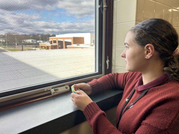 SHS student looks out the window and plays with something in her hand. 