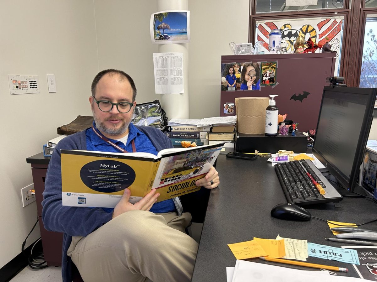 Mr. Anthony Lanfrank poses with the Sociology textbook for his new course.