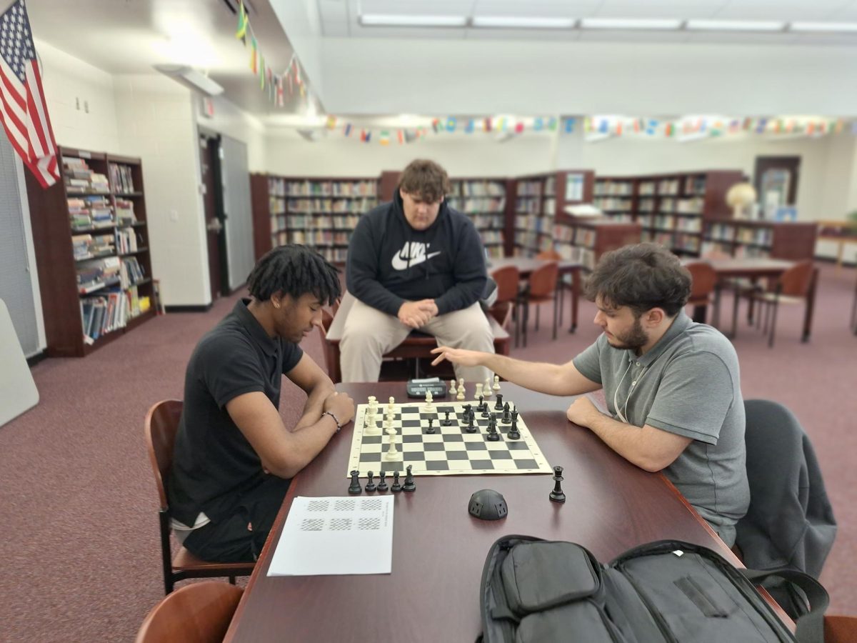 Chandler Lynch, 11, takes on Alex Morales, 12, in a practice game of chess while Santino Baxter, 11, looks on. 