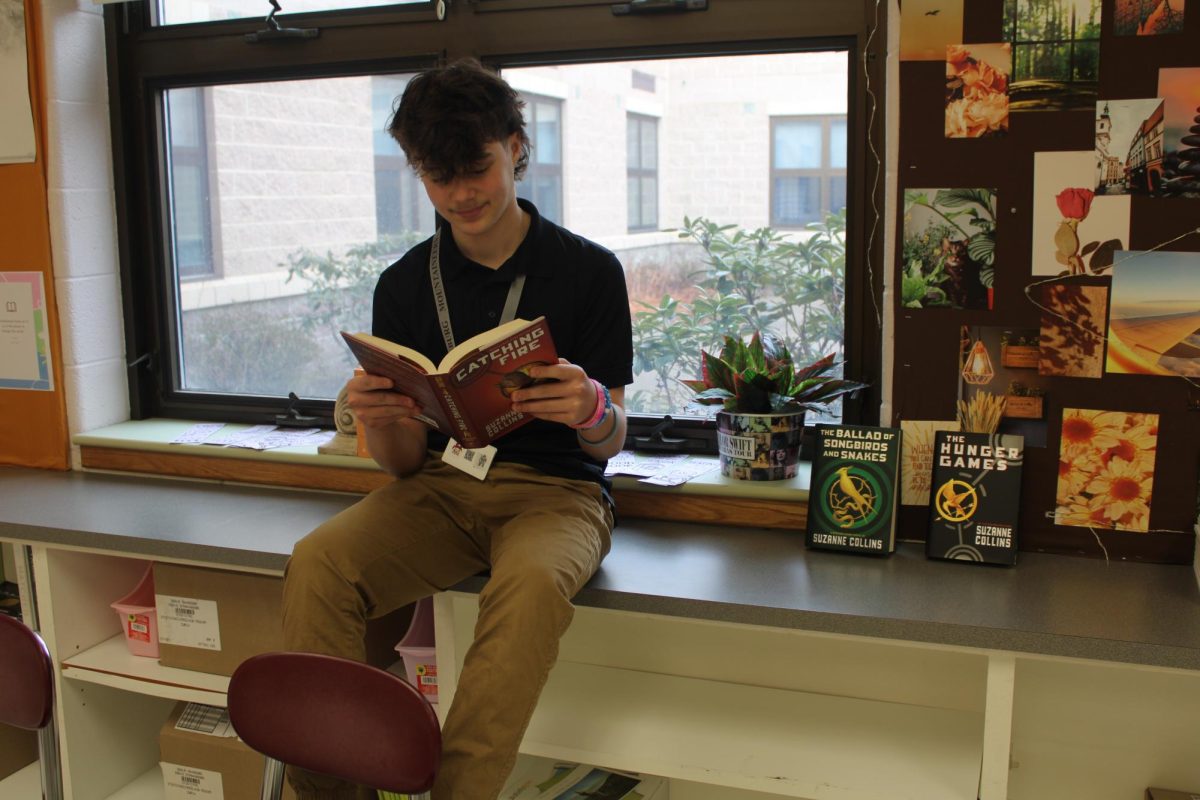 Photo of Stroudsburg Junior High School student Robert Rizzieri reading The Hunger Games book.
