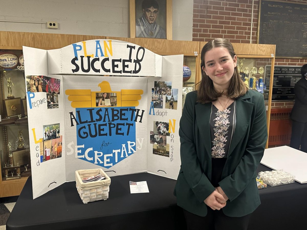 Alisabeth Guepet (11) poses with her candidate board for a Region 21 officer position.