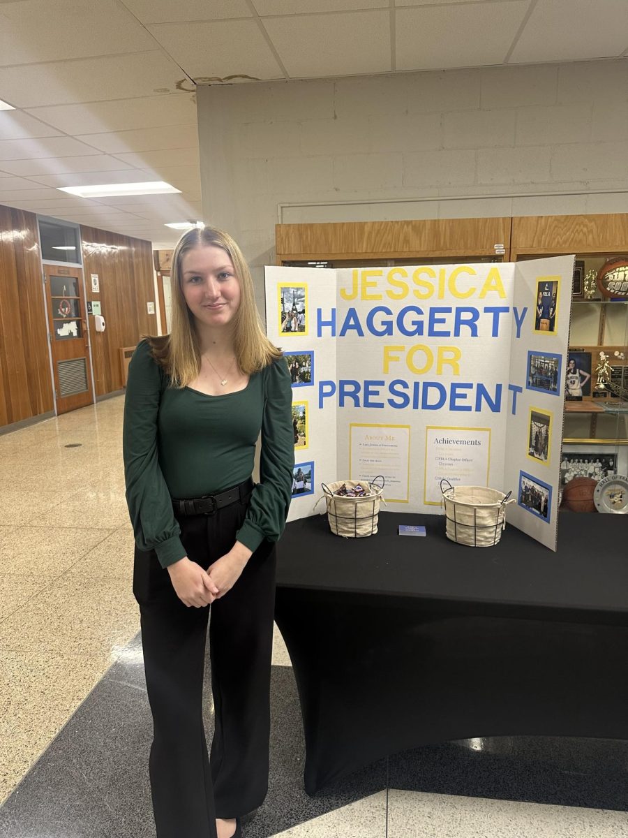 Jessica Haggerty (11) poses with a poster board acknowledging her achievements. 
