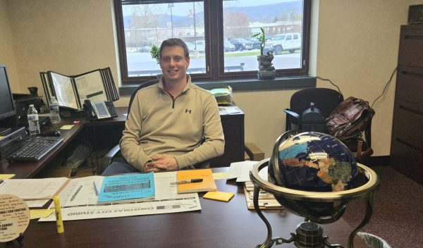 Mr.Romberger High School Vice Principal posing at his desk 