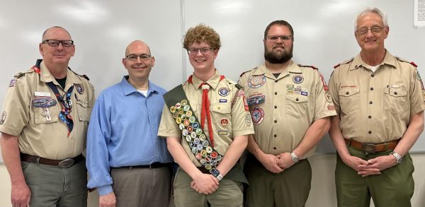 Logan Decker, 12, stands with his Scout Master and three members on the Eagle Board.