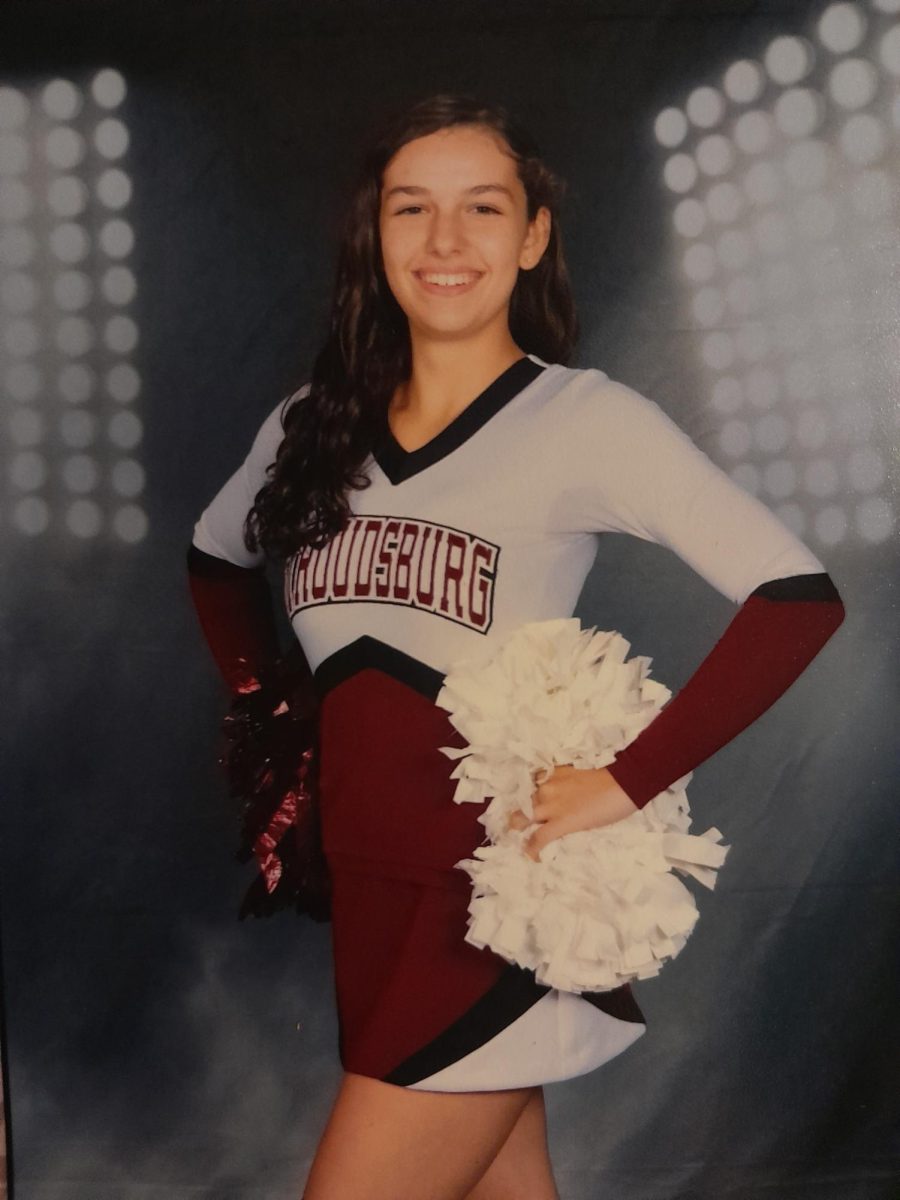 Ava Adamides in her cheerleading uniform smiling for the picture.