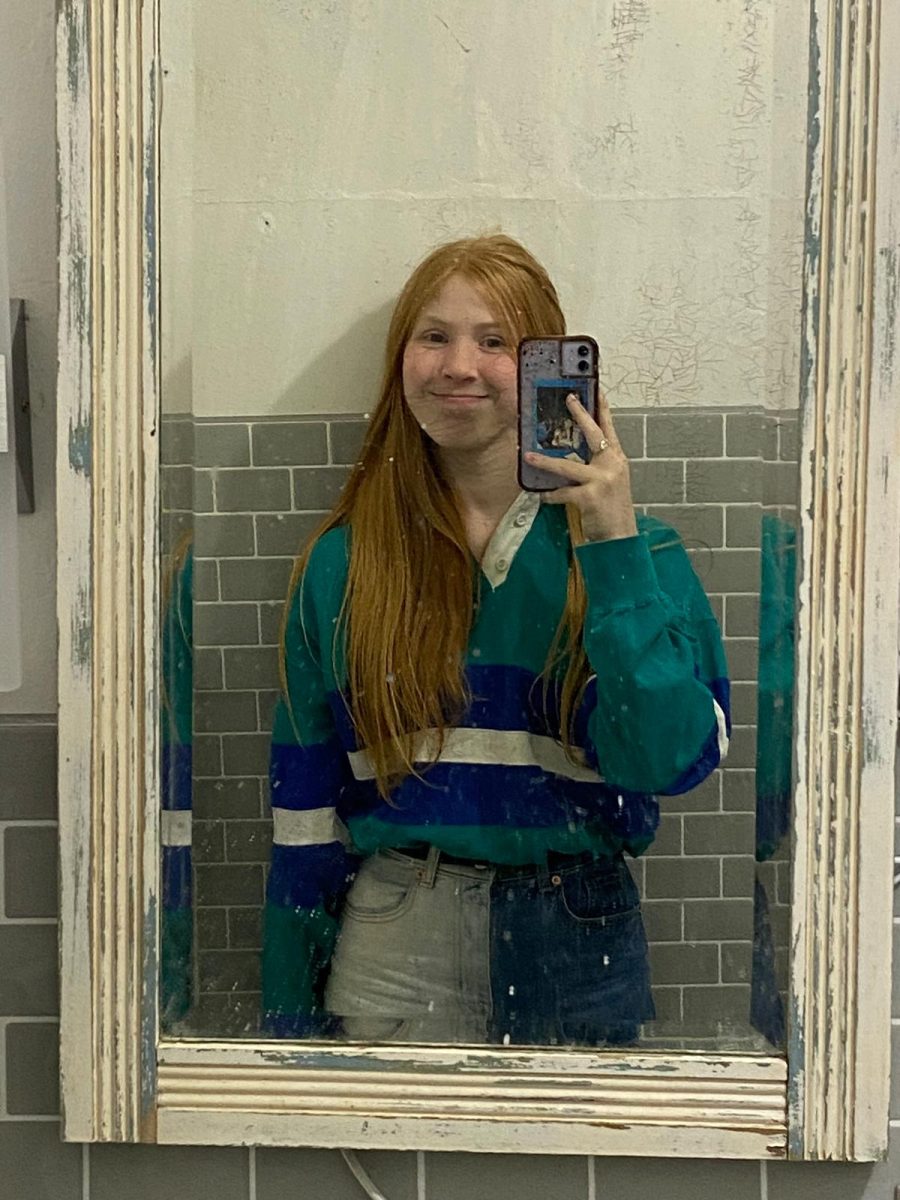 Julia Saurman smiling for a picture in the mirror.
