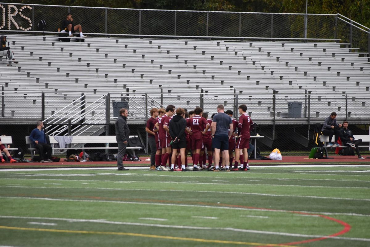 The boys soccer team huddles up at the start of an intense game.