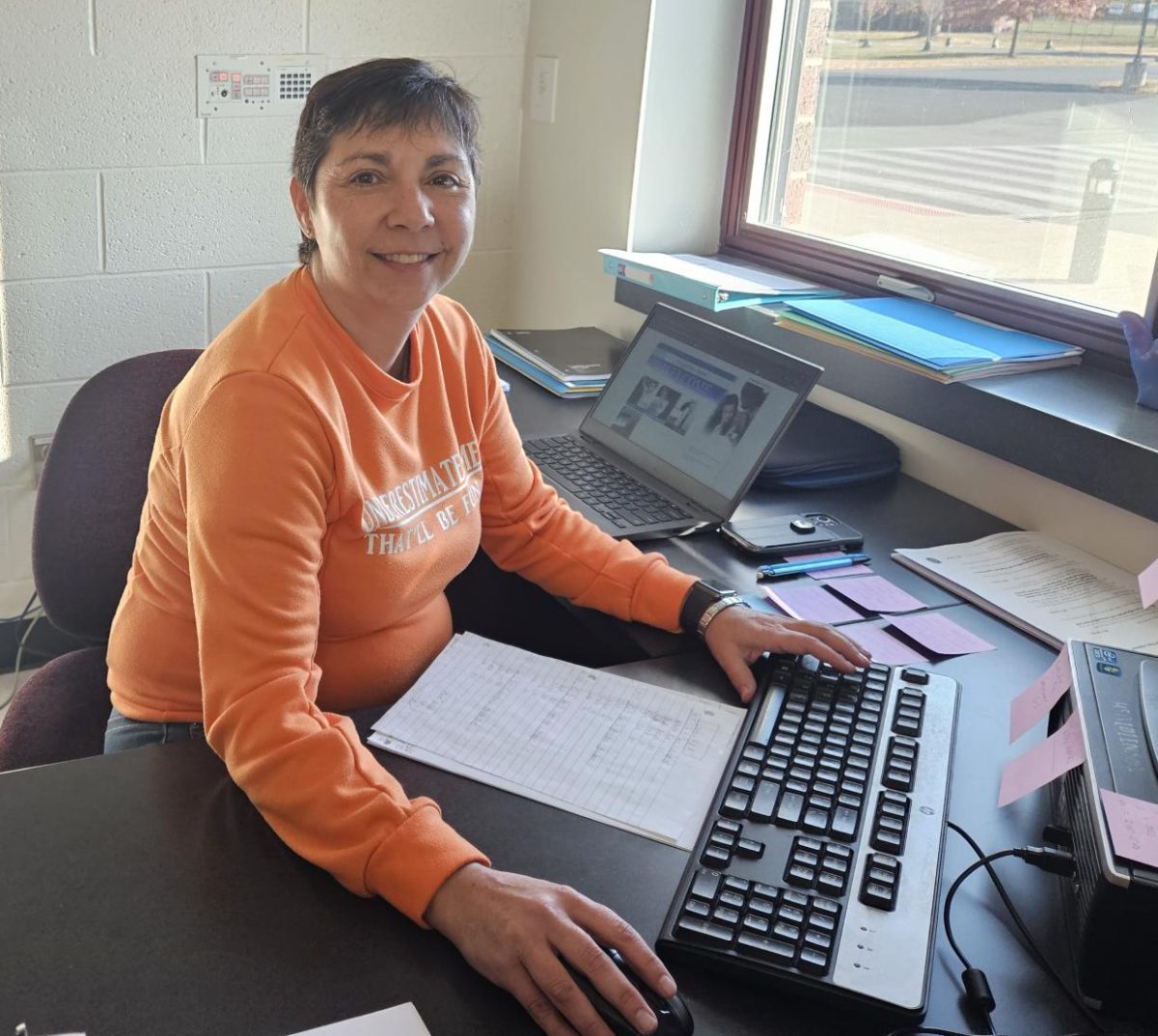 Ms. Nowosad sitting at her desk completing grades for her classes. 