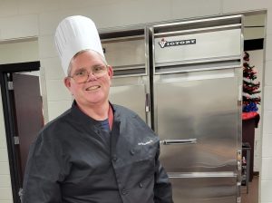 Mr. Burke dons a chef hat and coat while assisting in the SHS kitchen. Photo shared by Assistant Principal, Christine Gangaware.