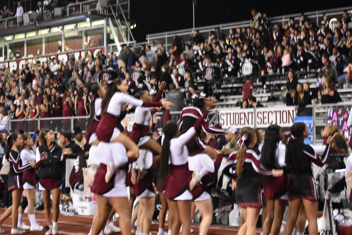 Stroudsburg cheerleaders lead the student section in their football chants, inspiring school spirit.  