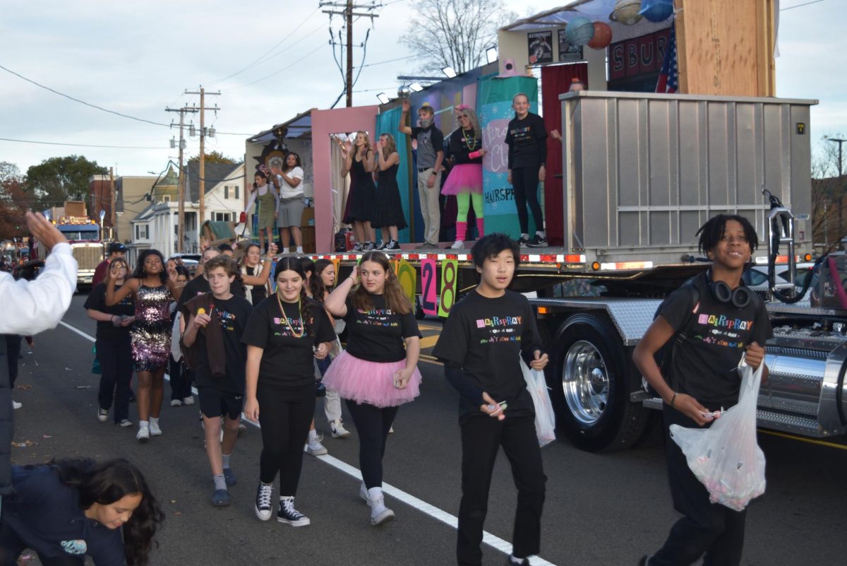 Class of '28 float participants walk in their first Homecoming Parade as high schoolers. 