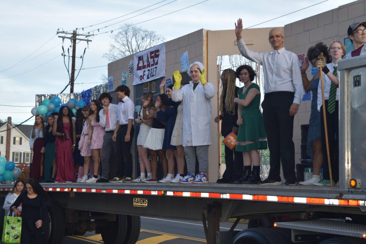 Float participants from Class of '27 wave to the crowd from their Back to the Future float.