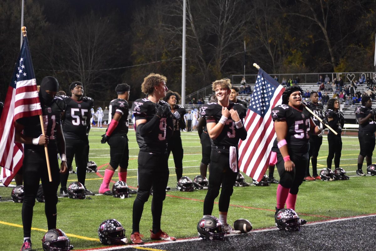 Benjamin Pilcher, ´25 and Ethan Dudsk, ´25 share words of encouragement before the playing of the National Anthem.