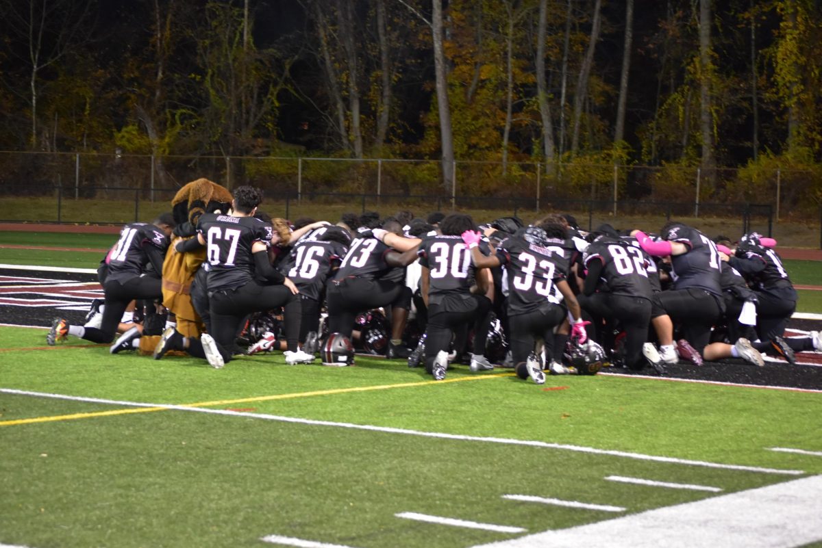 SHS football team, joined by the Stroudsburg mascot, huddle together in prayer before their game against Pleasant Valley.