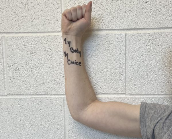 A female student flexing her arm to show the  right of choice.