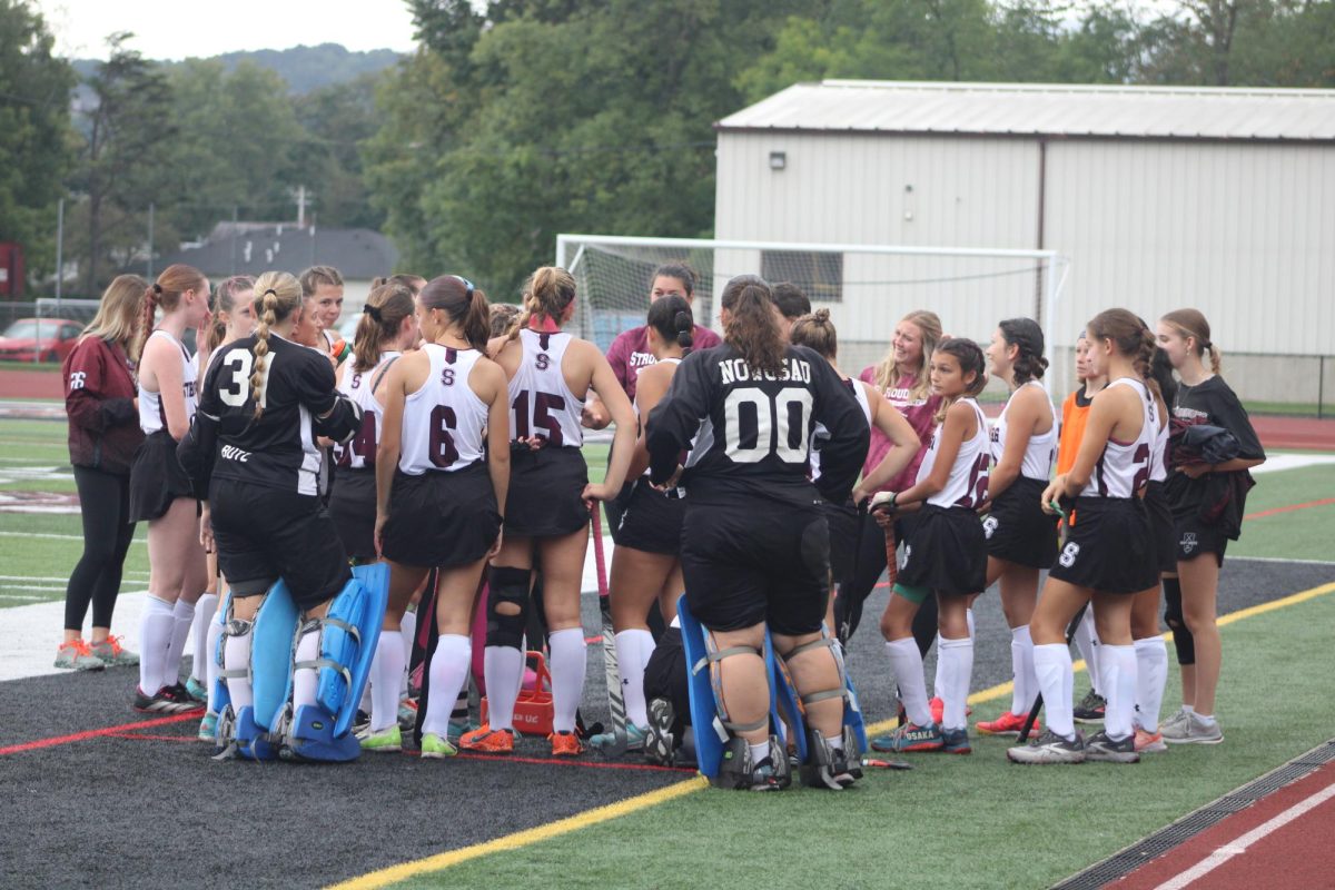 Stroudsburg field hockey team waiting to start a new quarter and talking about their next plays.