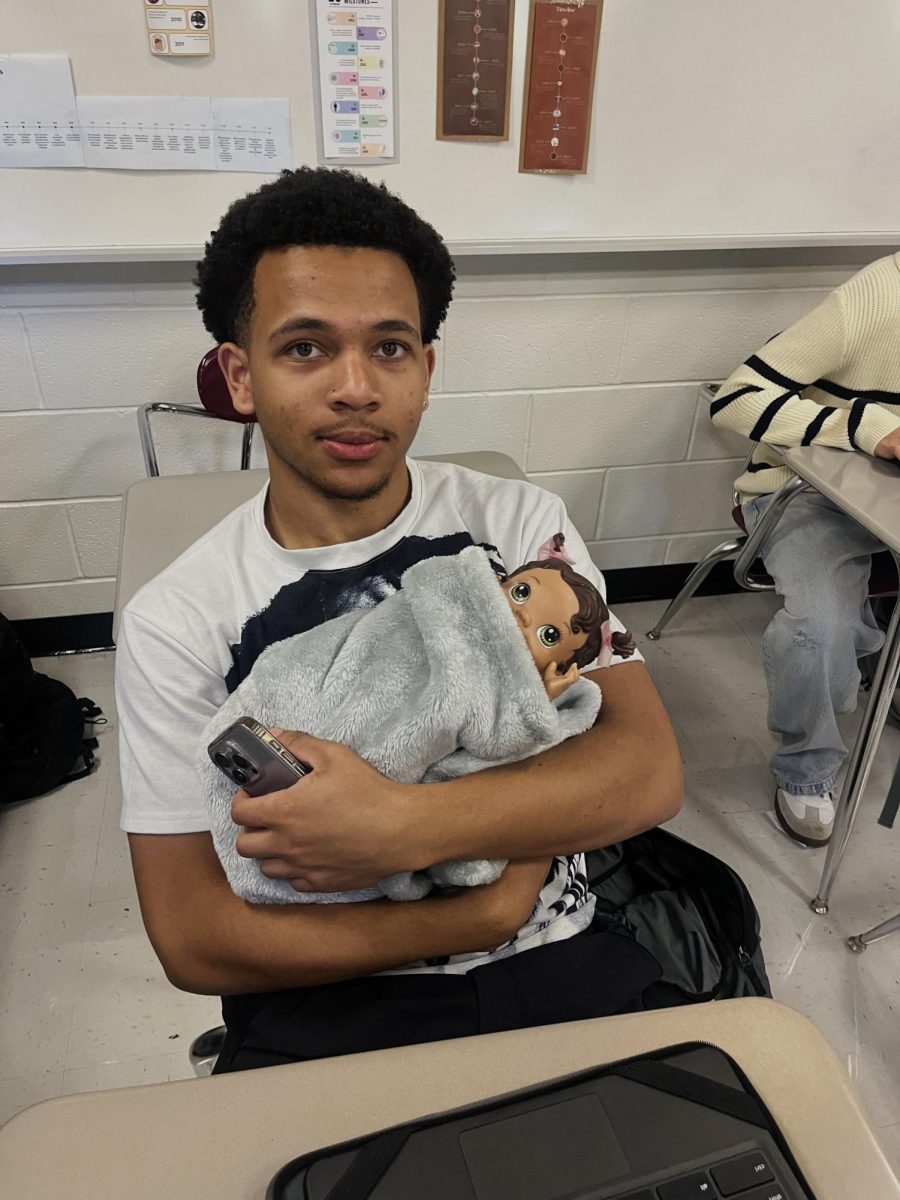 Deon Davis '26 is a parent with a baby for Dress Your Age.