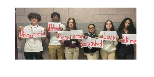 Teenagers in SHS line up against a wall while displaying names/stereotypes applied to the current generation of teenagers. 