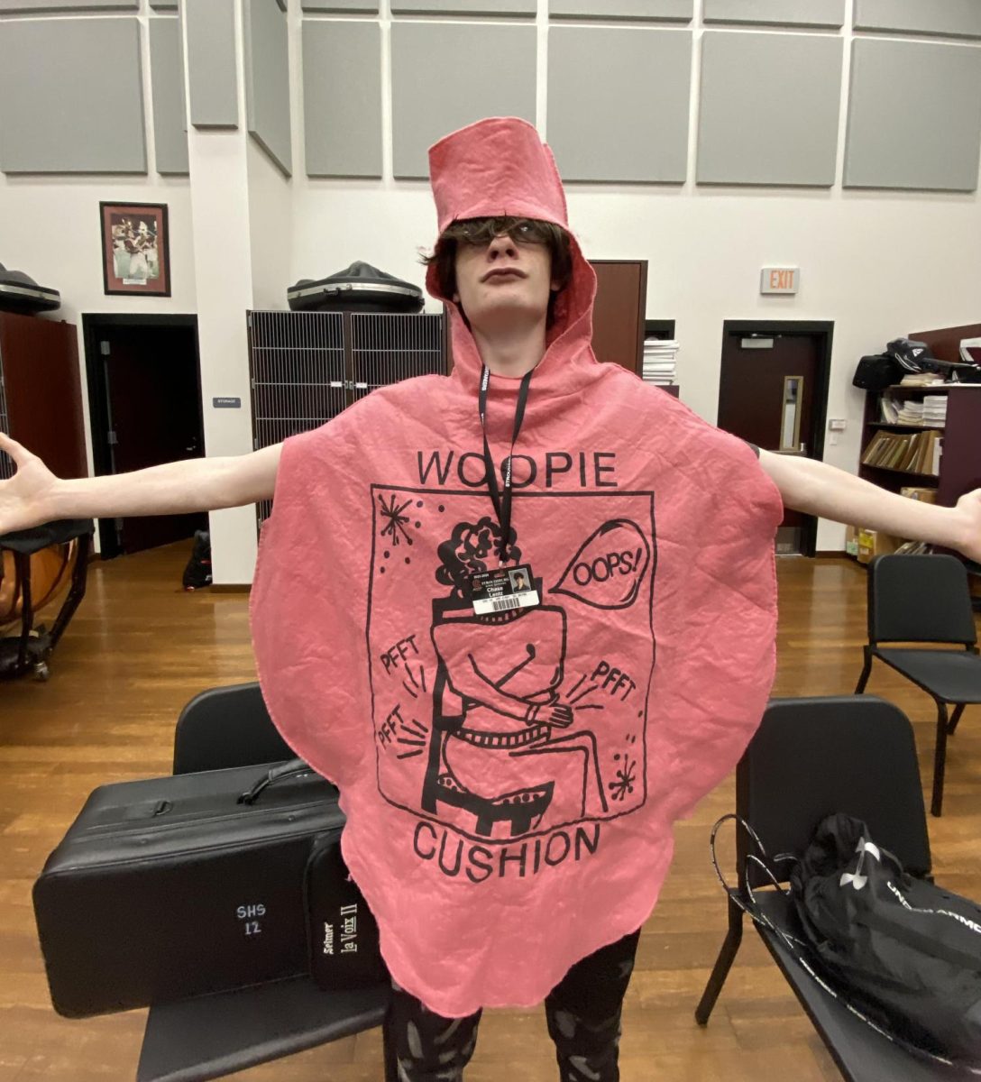 Chase Lentz, '26, dressed as a Whoopy cushion for Halloween and poses in the orchestra room. Photo provided by Sophia Hann, '27.