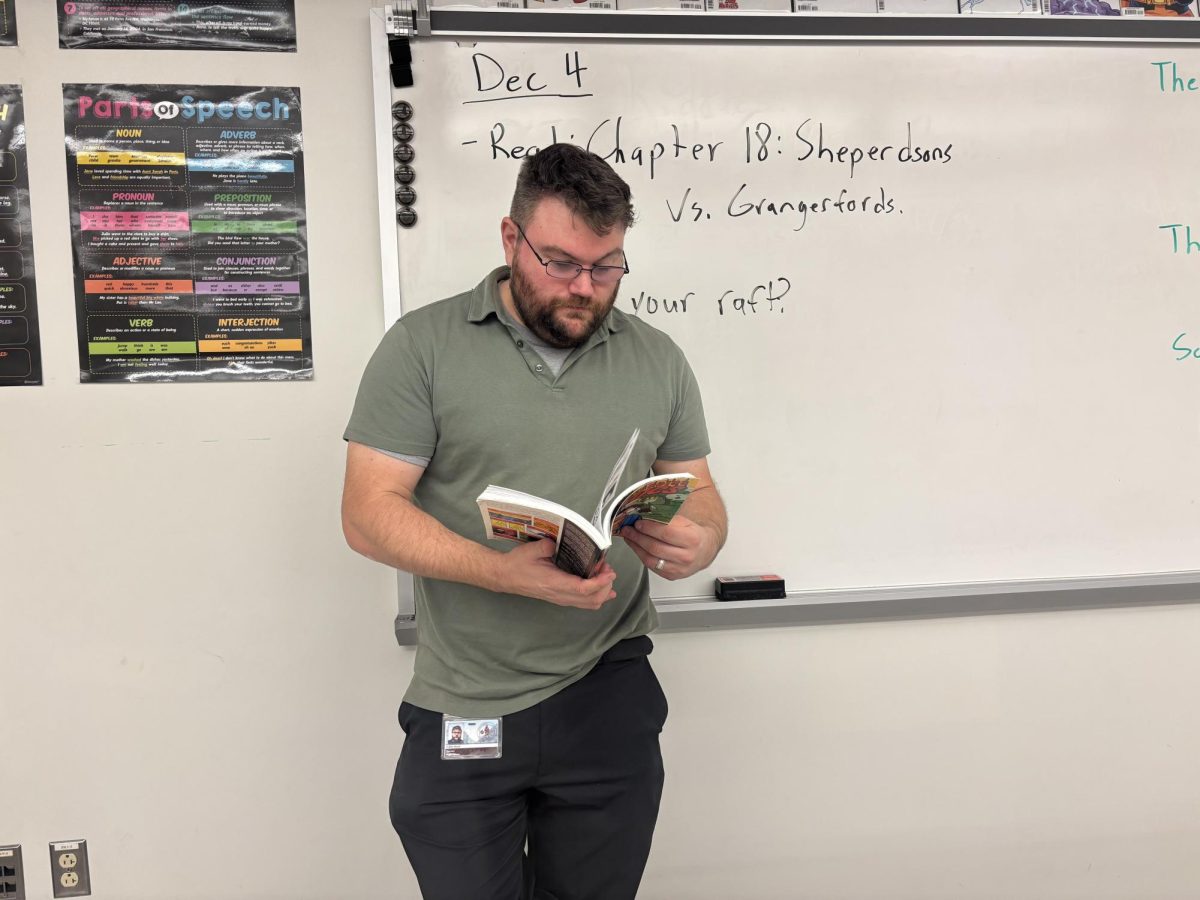 Mr. Robert Wood reads a comic; the primary focus of The Study of Graphic Novels course that is being added as an elective. 