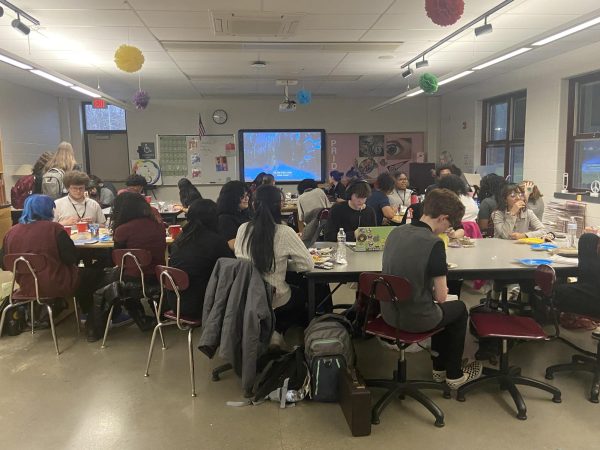 DEI and Art students creating Christmas cards while watching a movie. 