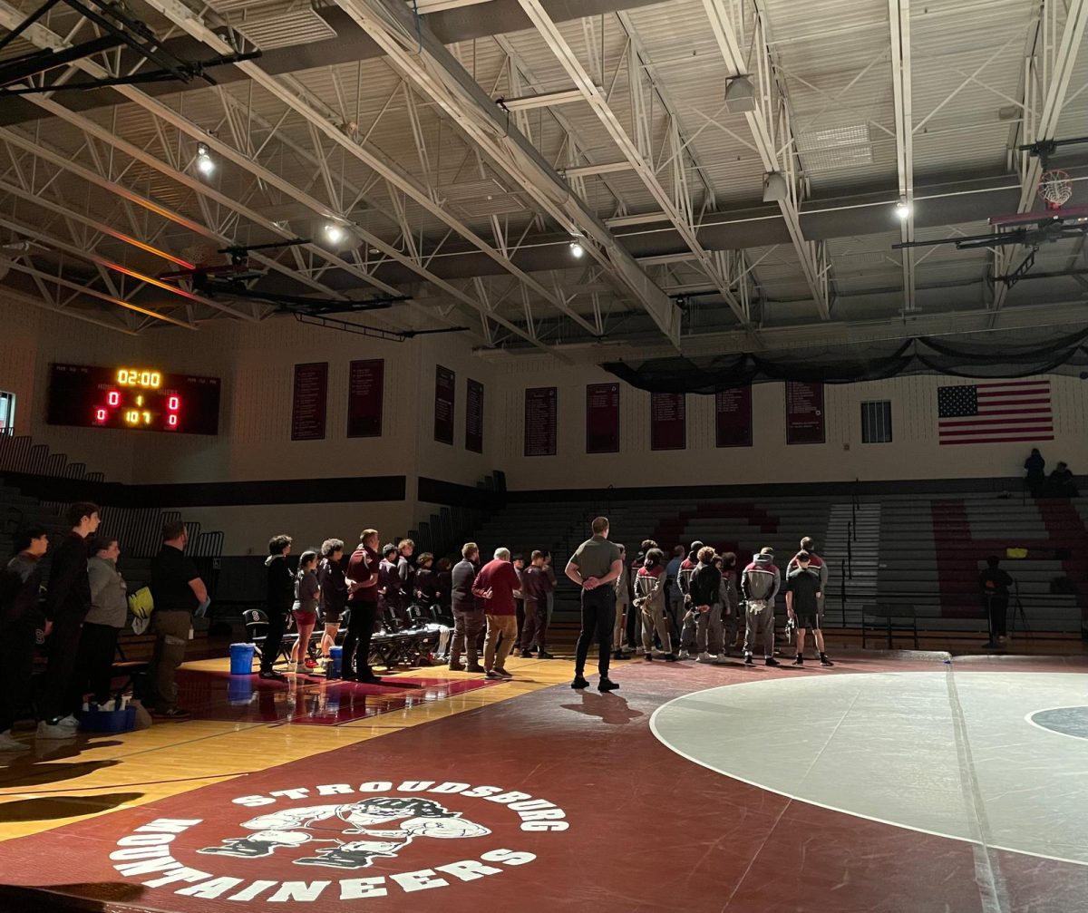 SHS Wrestling teams standing up and pledging allegiance to the American flag.