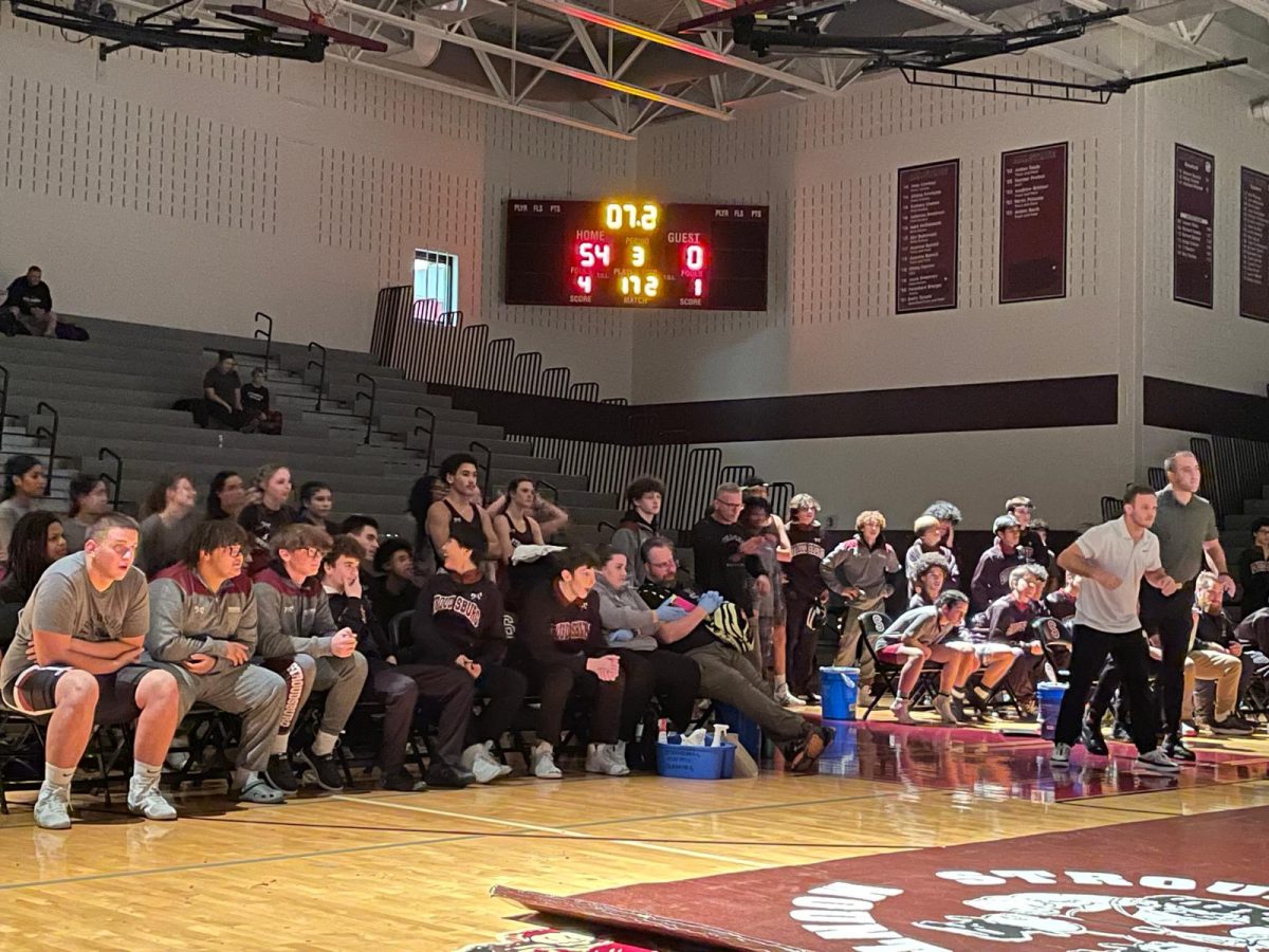 The SHS Boys and Girls Wrestling teams watch their peers' matches intently.