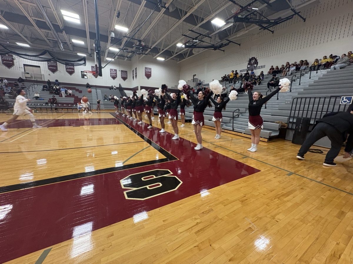 SHS Cheer team chanting on the sidelines before a basketball game. 