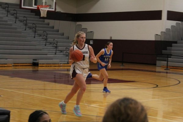 Adriana Borzio, '26 carrying the ball up the court after scoring against Pleasant Valley. 