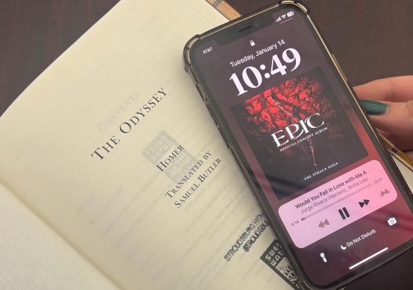 A photo of "The Odyssey" next to a phone showing a song from "Epic: The Musical".