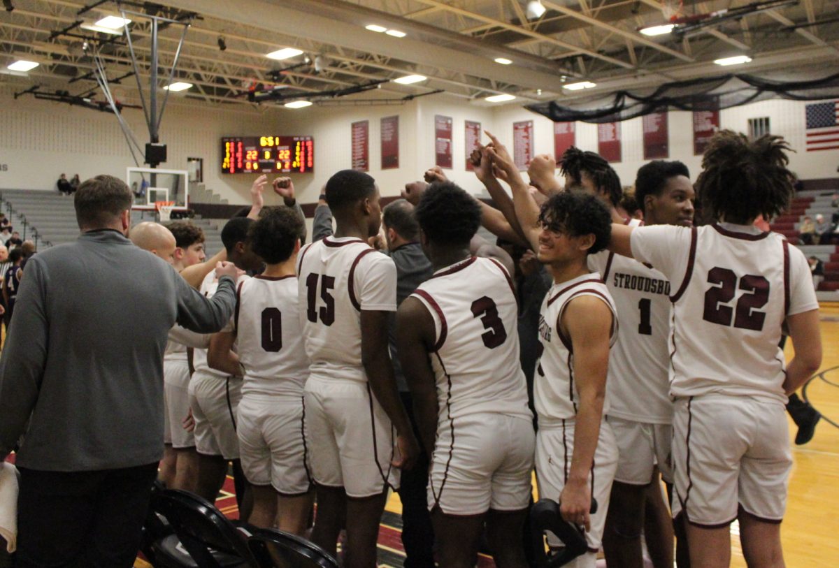 The varsity basketball team huddles at halftime to debrief with the coach.