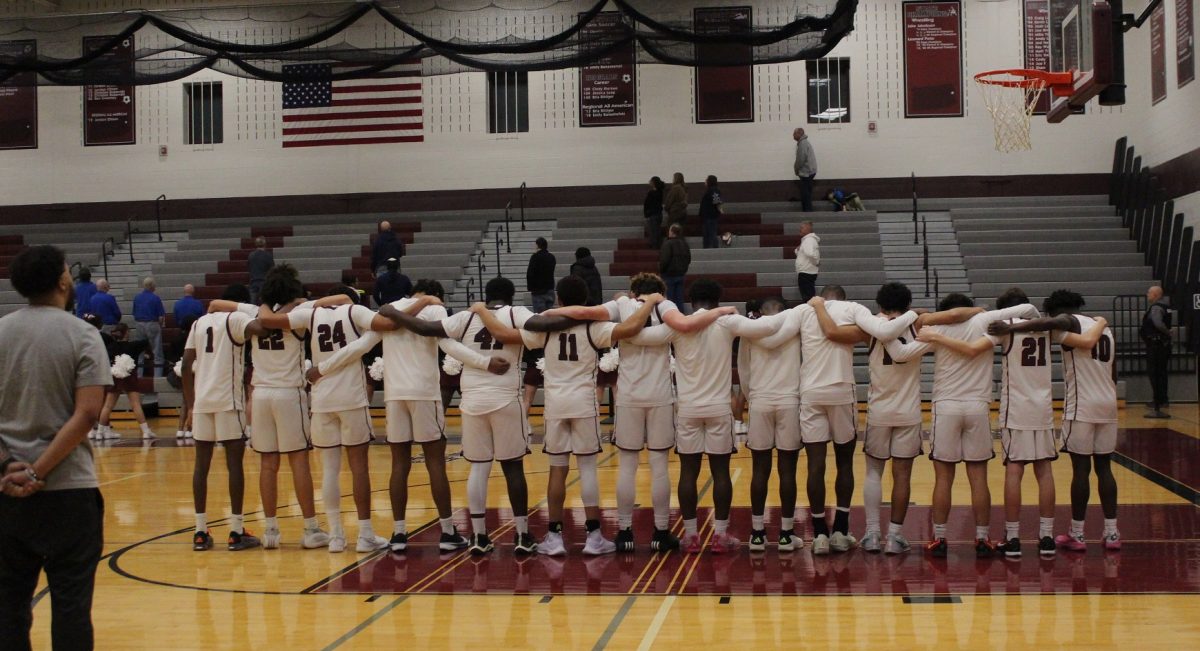 The boys, basketball team pay their respects during the National Anthem.