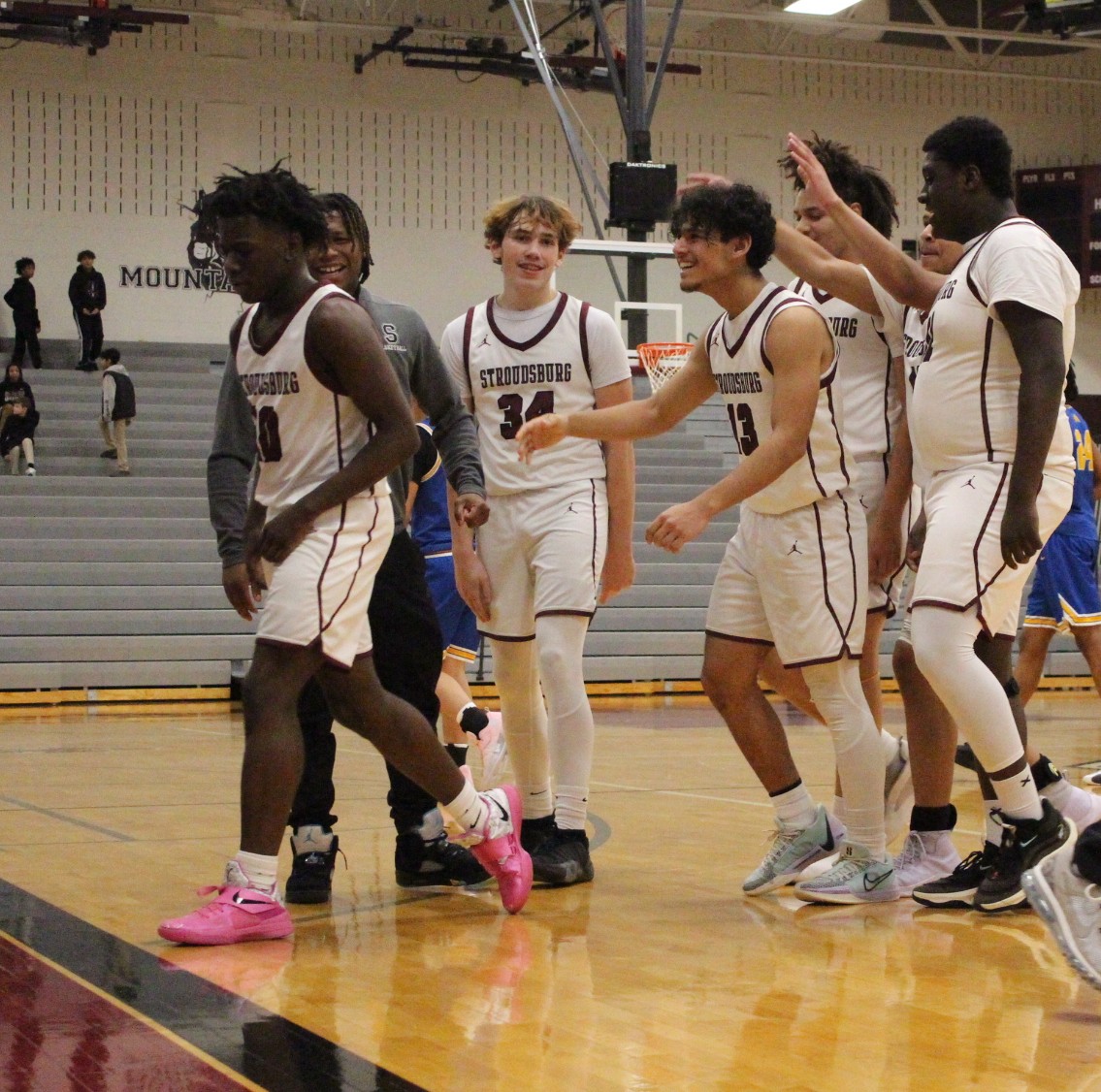 Teammates congratulating Michael Gilmore, '27, on adding points to he scoreboard. 