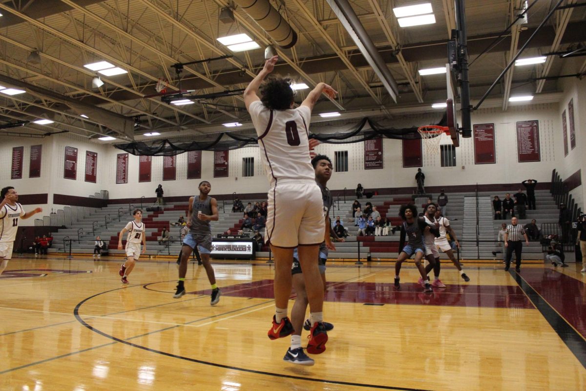 Alex Paciti, '25, making a three pointer.