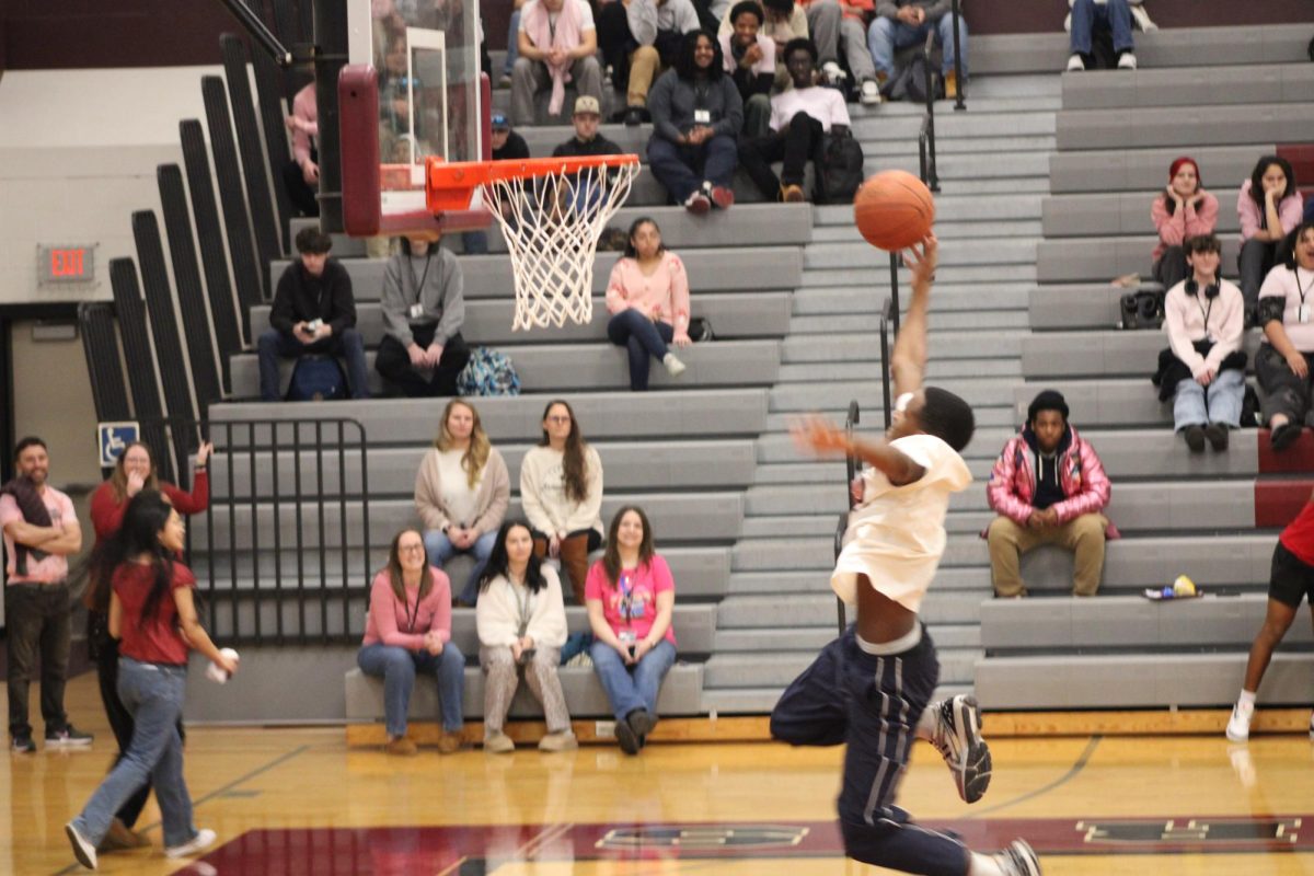 One of the basketball teammates shooting into the hoop.