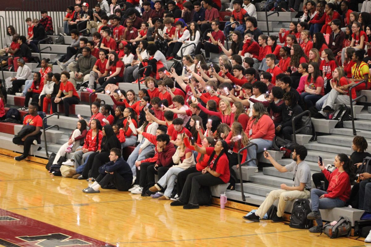 The junior section waving their flashlights while the colorguard performs.