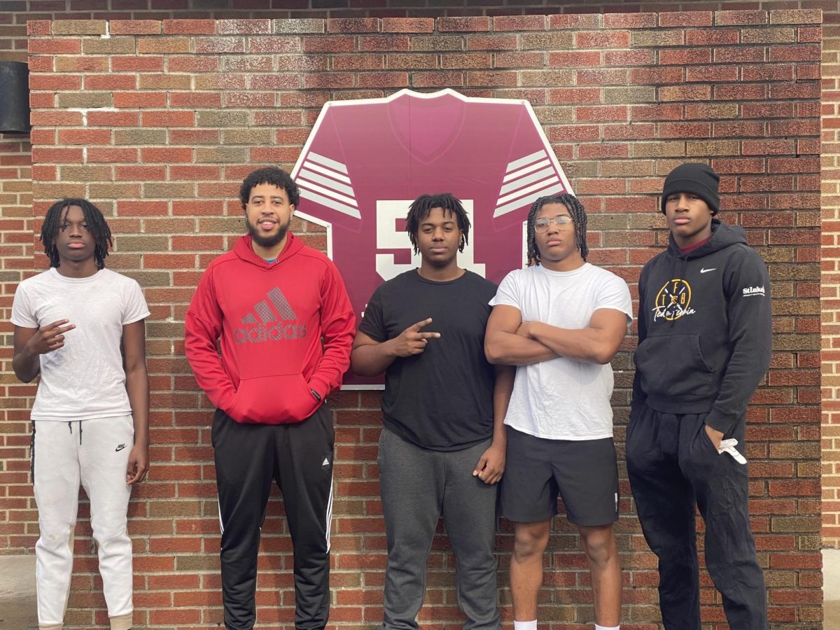 Coach Watkins, strength trainer, stands with members of Stroudsburg's football team. during off-season training. 