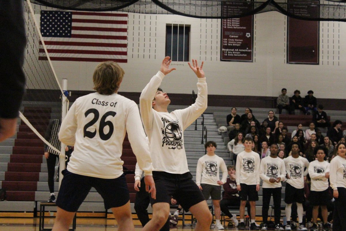 Aidan Brier, a member of the junior class team, sets the ball for his teammate. 