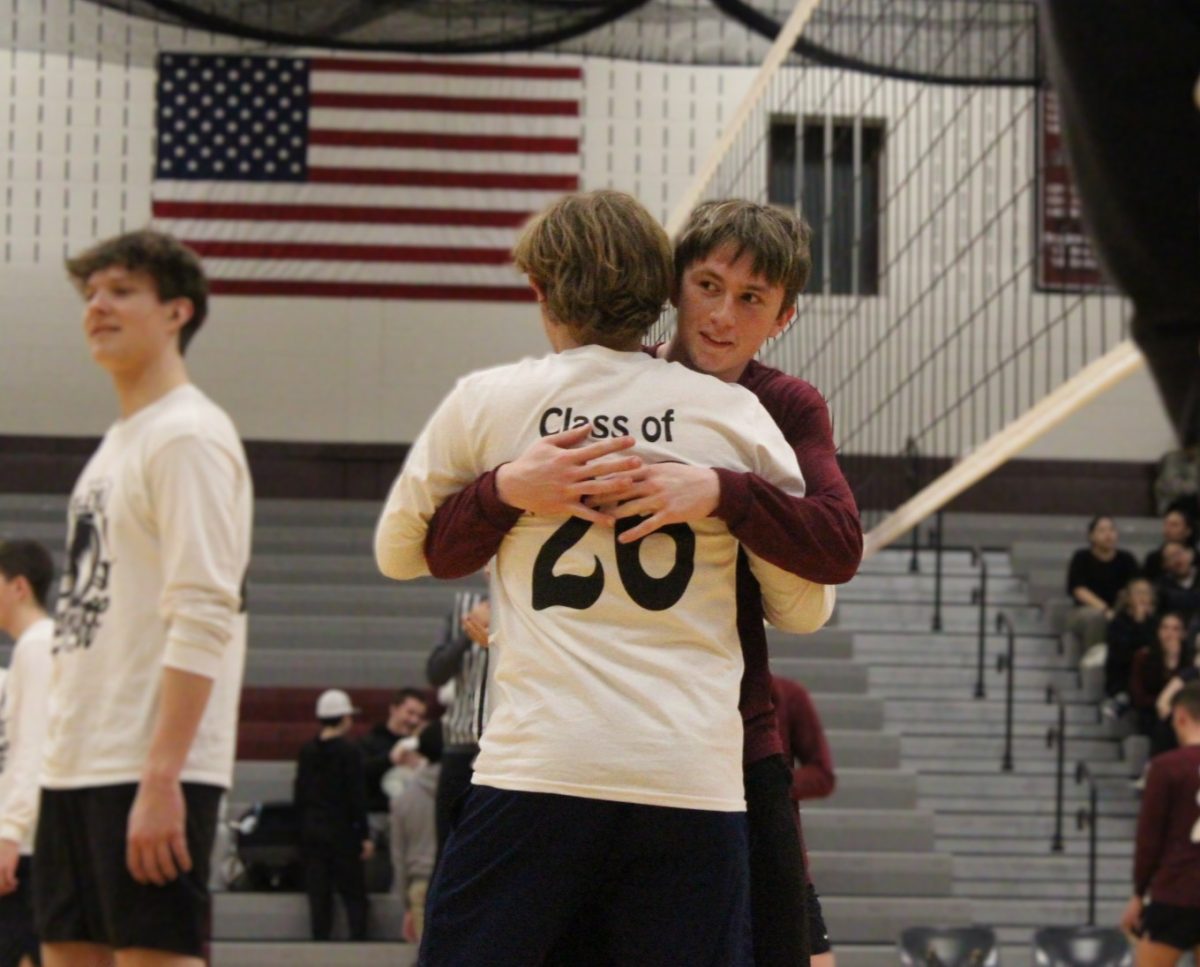 Two members of opposing teams hug before their game.