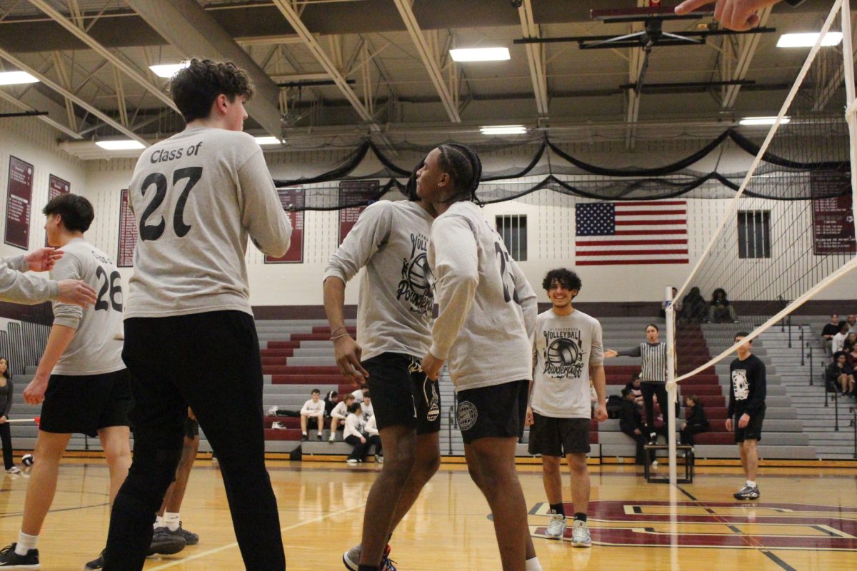 Two members of the combined class team chest bump to celebrate a point.