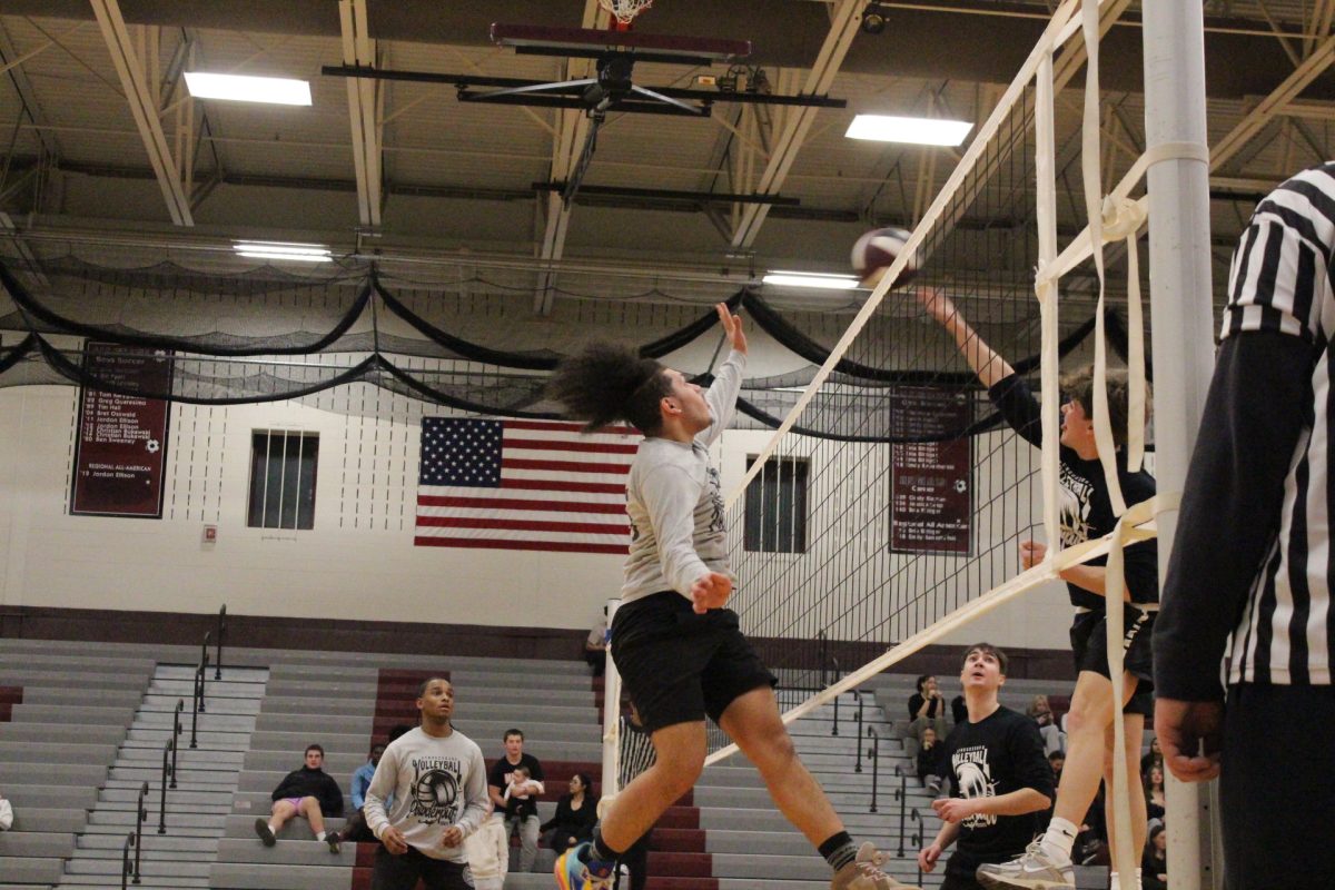 A member of the combined-class team blocks the ball from going over the net.